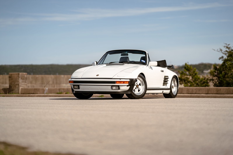 White 1988 Porsche 930 Turbo Slantnose convertible with Fuchs wheels and black soft top.