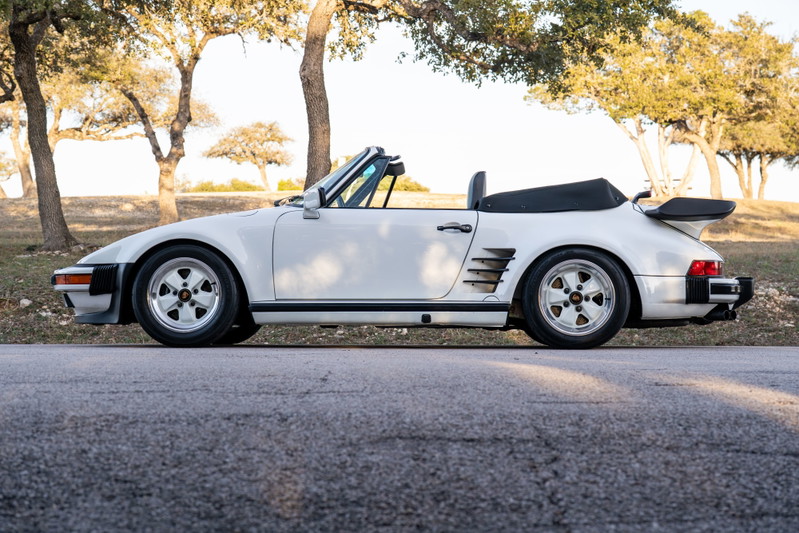 White 1988 Porsche 930 Slantnose convertible with a whale tail spoiler and Fuchs rims.