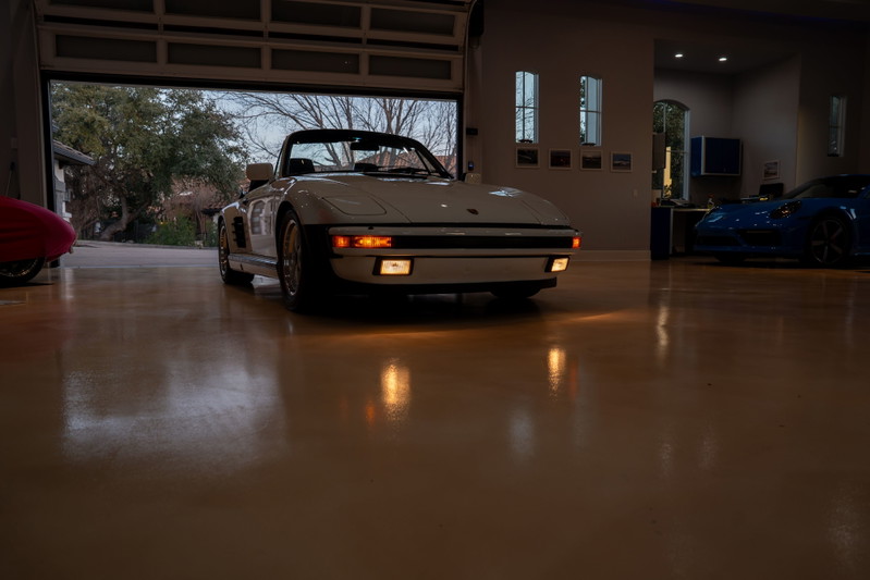 1988 white Porsche 930 Slantnose Turbo convertible with black trim and classic alloy rims.