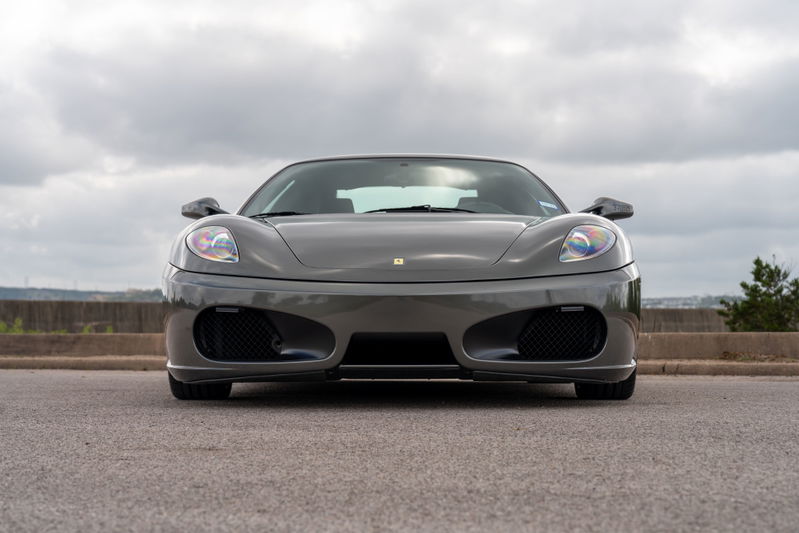 Front view of a Grigio Silverstone 2007 Ferrari F430 6-speed with black grilles and chrome trim.