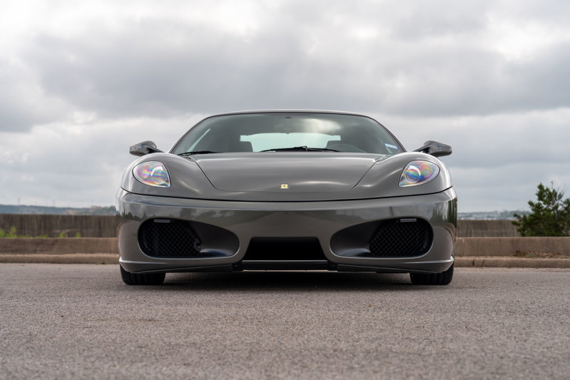 Front view of a Grigio Silverstone 2007 Ferrari F430 6-speed with black grilles and chrome trim.
