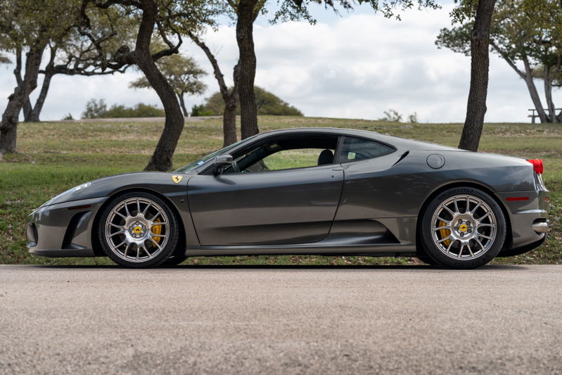 A Grigio Silverstone 2007 Ferrari F430 6-speed with aftermarket silver rims and yellow brake calipers.