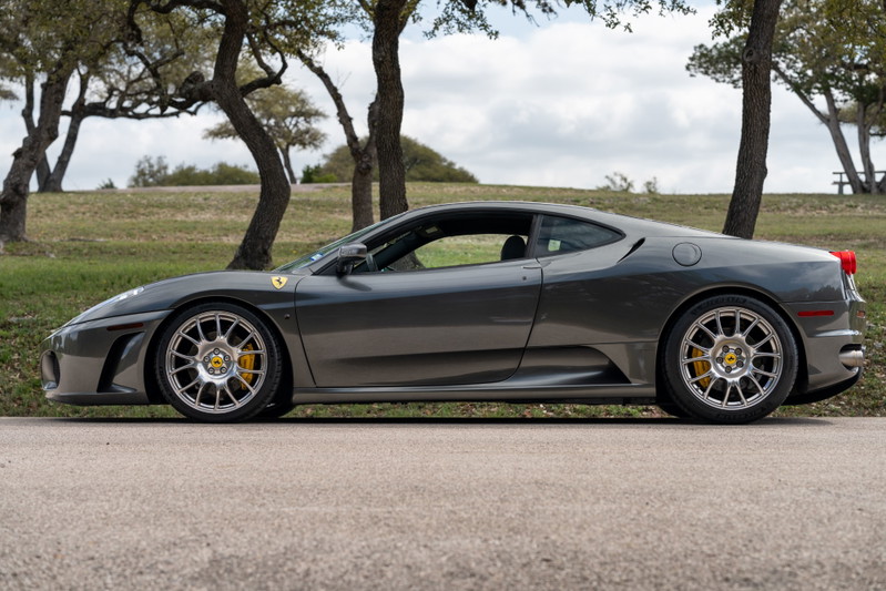 A Grigio Silverstone 2007 Ferrari F430 6-speed with aftermarket silver rims and yellow brake calipers.