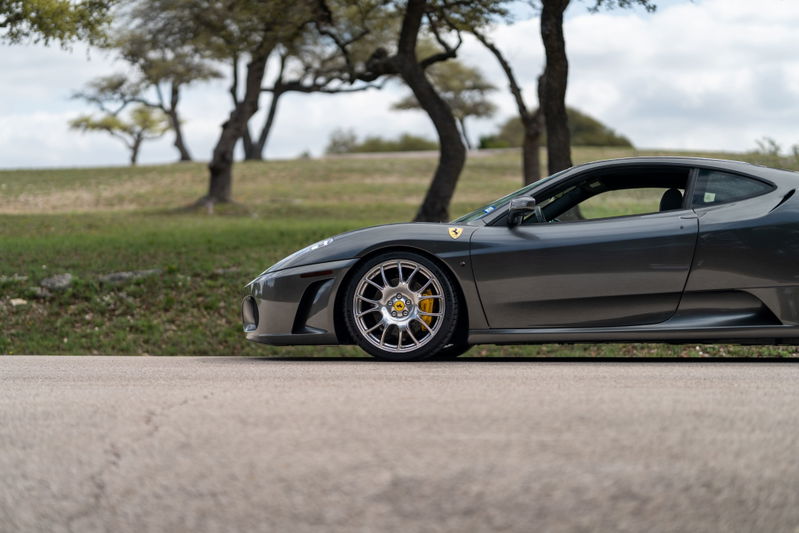 Side profile of a Grigio Silverstone 2007 Ferrari F430 6-speed with aftermarket mesh rims and yellow brake calipers.