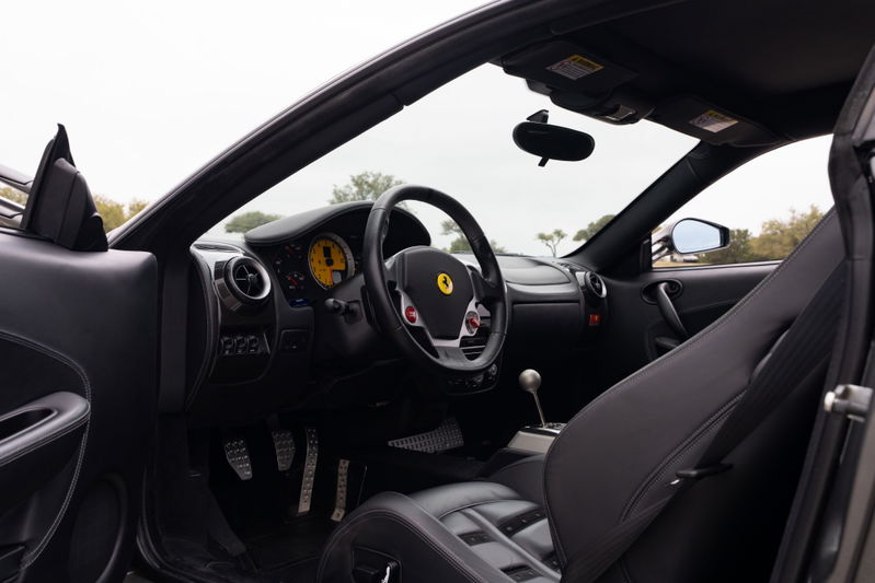 Black leather interior of a 2007 Ferrari F430 6-speed, Grigio Silverstone exterior.