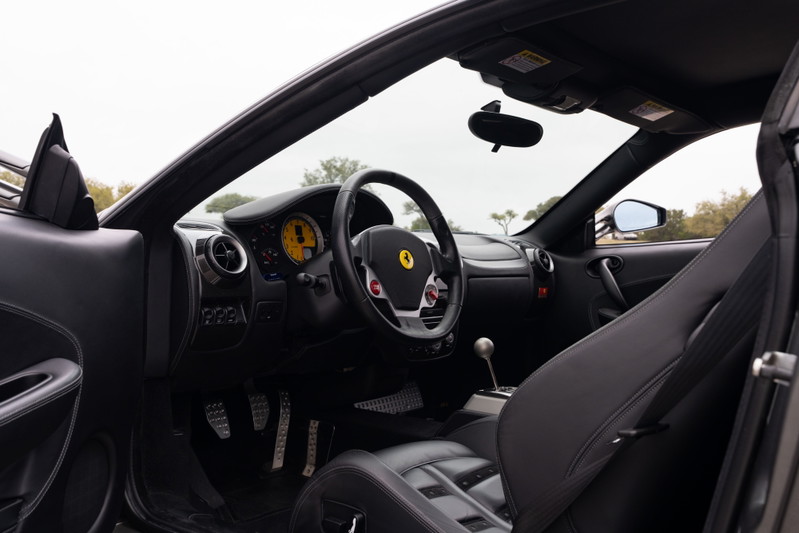 Black leather interior of a 2007 Ferrari F430 6-speed, Grigio Silverstone exterior.