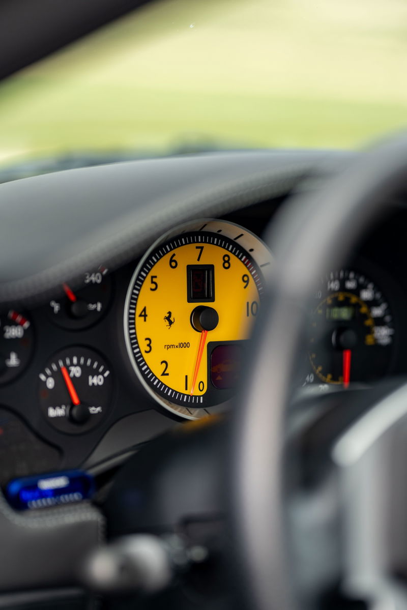Close-up of yellow tachometer in a Grigio Silverstone 2007 Ferrari F430, showing RPM.