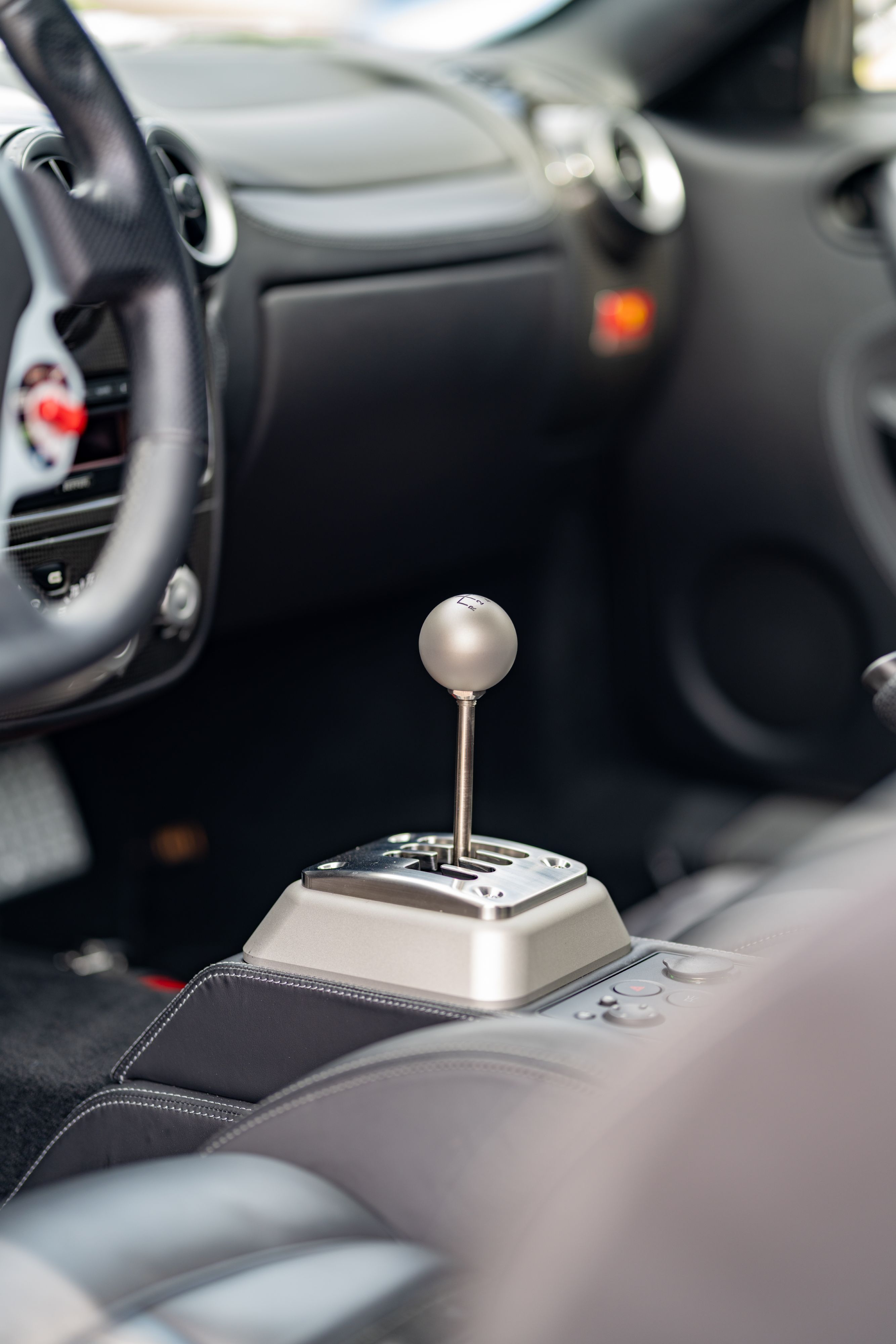 Close up of a gated manual shifter in a Grigio Silverstone 2007 Ferrari F430.