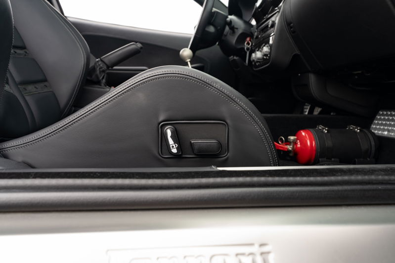 Ferrari F430 6-speed interior showing racing seat controls and fire extinguisher.