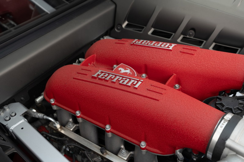 Close up of red Ferrari F430 engine covers with silver Ferrari script.