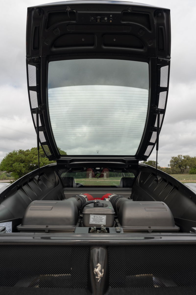 Ferrari F430 6-speed engine bay with twin intake plenums and red air intake trumpets. Grigio Silverstone.