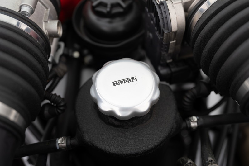 Close-up of the Ferrari F430 engine bay, highlighting the silver Ferrari-branded cap.