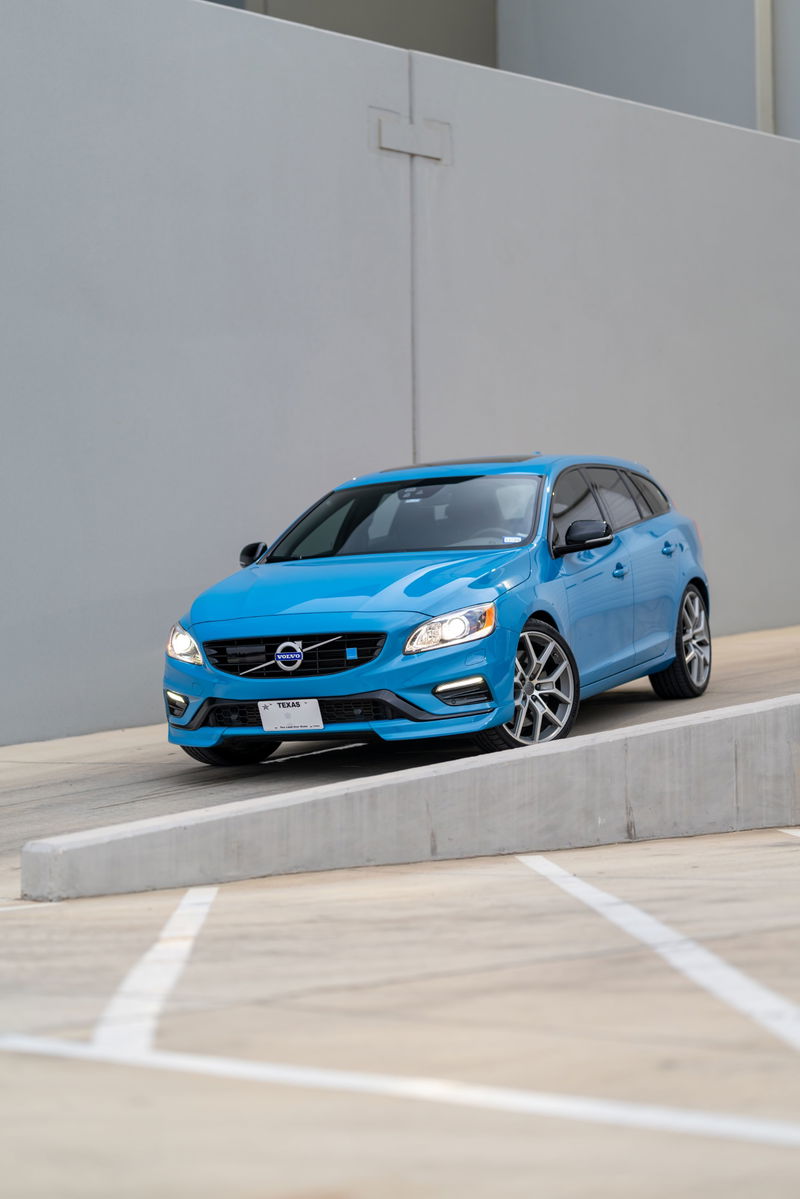 A Rebel Blue 2015 Volvo V60 Polestar with silver rims and black trim is parked on a ramp.