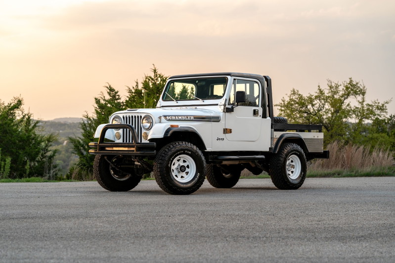 1983 Jeep Scrambler pickup truck with a white exterior, black trim, and white rims.