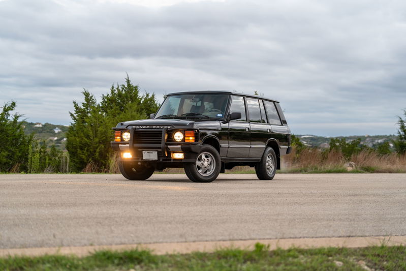 1994 Land Rover Range Rover County LWB in black, featuring classic quad headlights and 5-spoke rims.