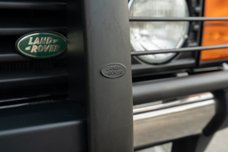 Close-up of a 1994 Land Rover Range Rover County LWB's black brush guard with Land Rover emblems and headlights.