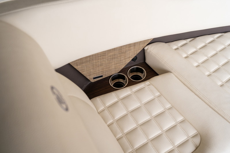 Cobalt R7 Surf boat interior features diamond-stitched cream upholstery and built-in cup holders.
