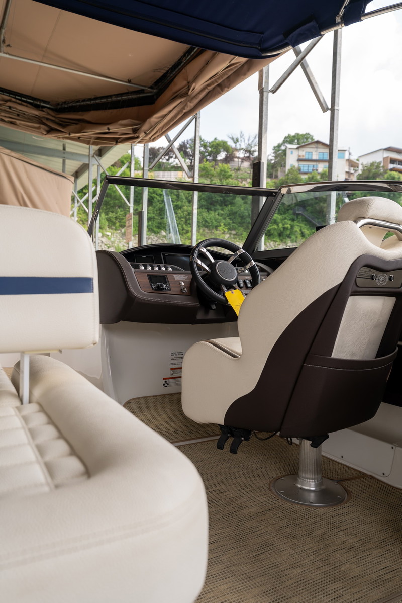 Cobalt R7 Surf boat interior with two-tone captain's chairs, wood trim, and a digital dash.