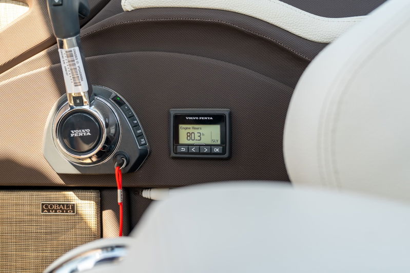 Close-up of Cobalt R7 Surf boat's helm: Volvo Penta throttle, digital display, and Cobalt Audio speaker.