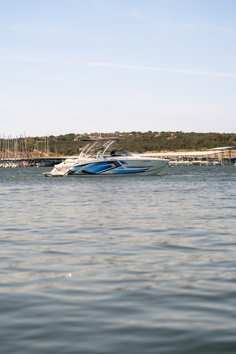 White 2018 Cobalt R7 Surf boat with a blue wave livery speeds through the water.