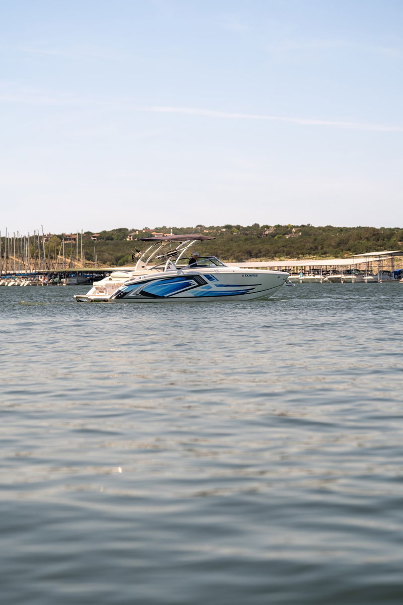 White 2018 Cobalt R7 Surf boat with a blue wave livery speeds through the water.