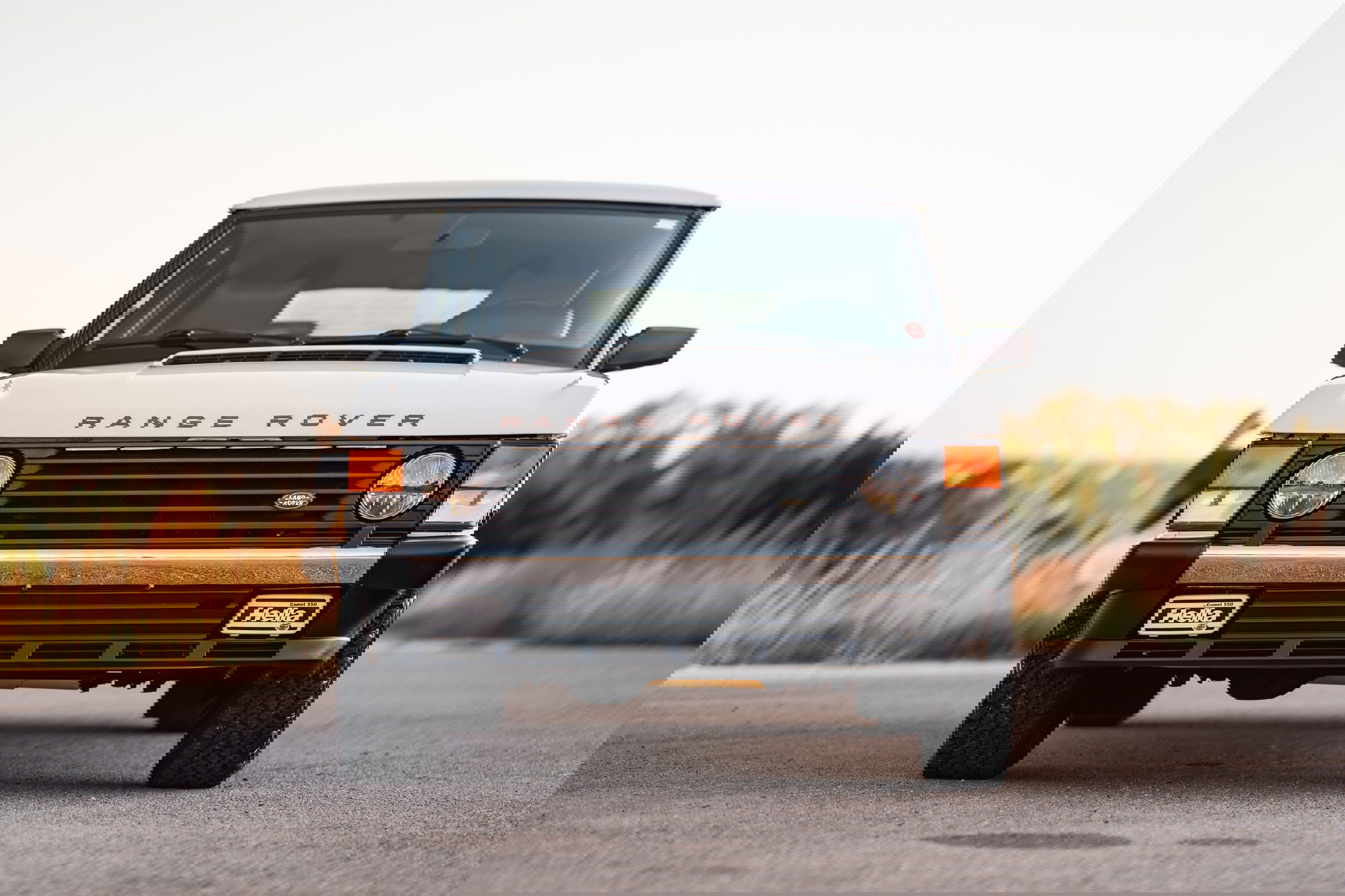 Front view of a white 1995 Range Rover County with black trim and Hella fog lights.