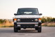 Front view of a white 1995 Range Rover County with black trim and Hella fog lights.