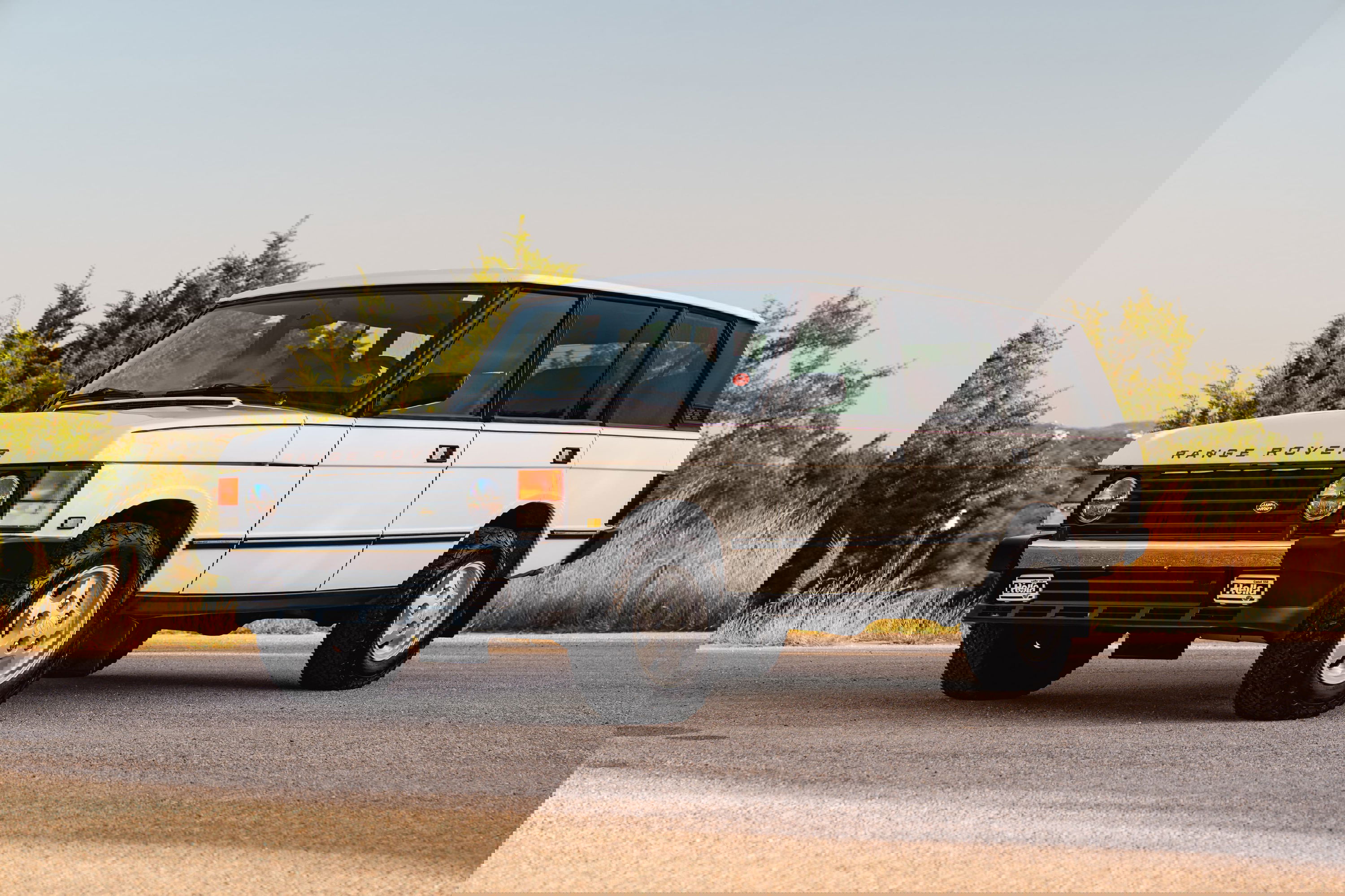 White 1995 Range Rover County edition with chrome accents and classic alloy rims.