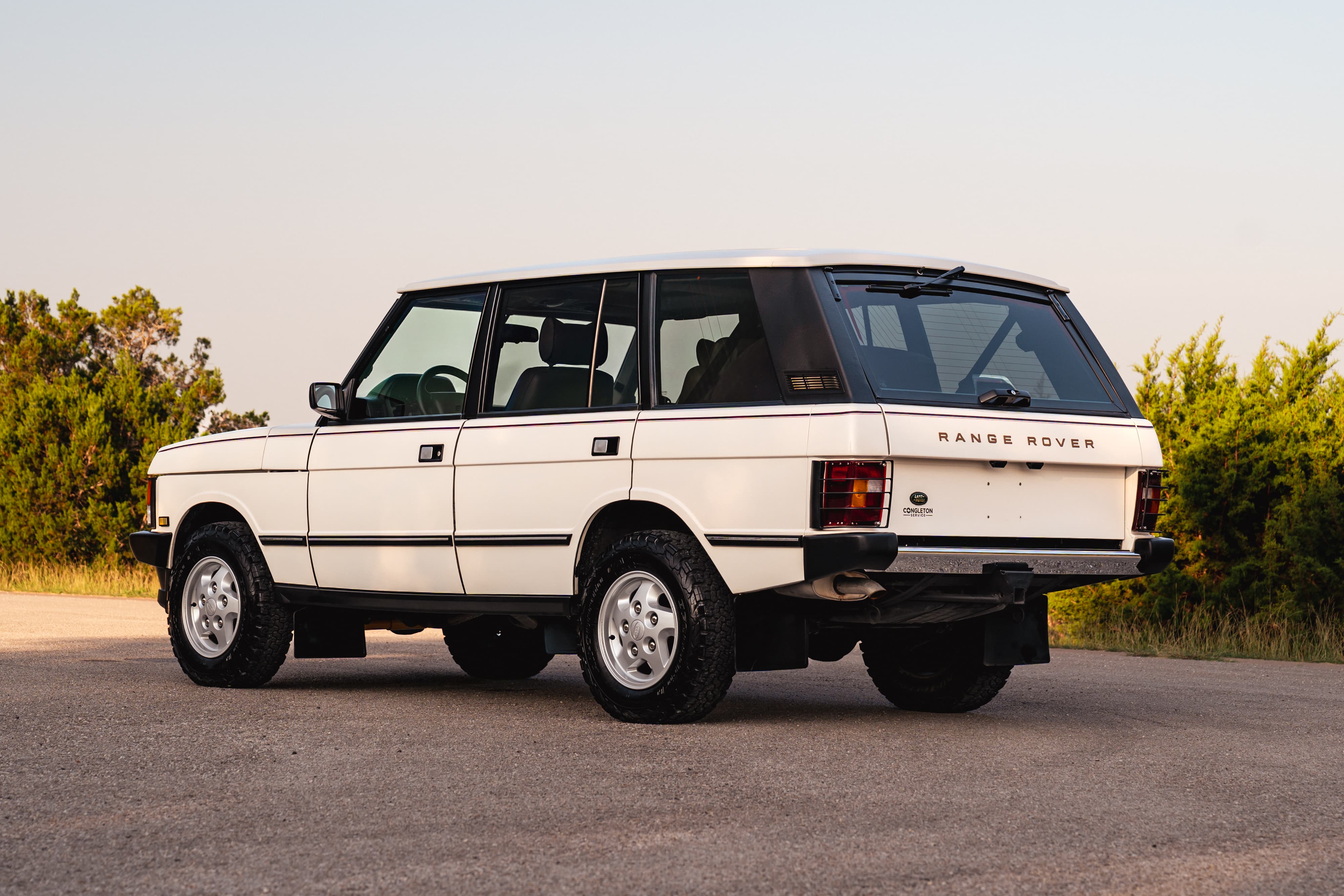 Rear view of a white 1995 Land Rover Range Rover County with chrome rims and black trim.