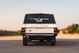Rear view of a white 1995 Range Rover County with mud flaps and rugged rims.