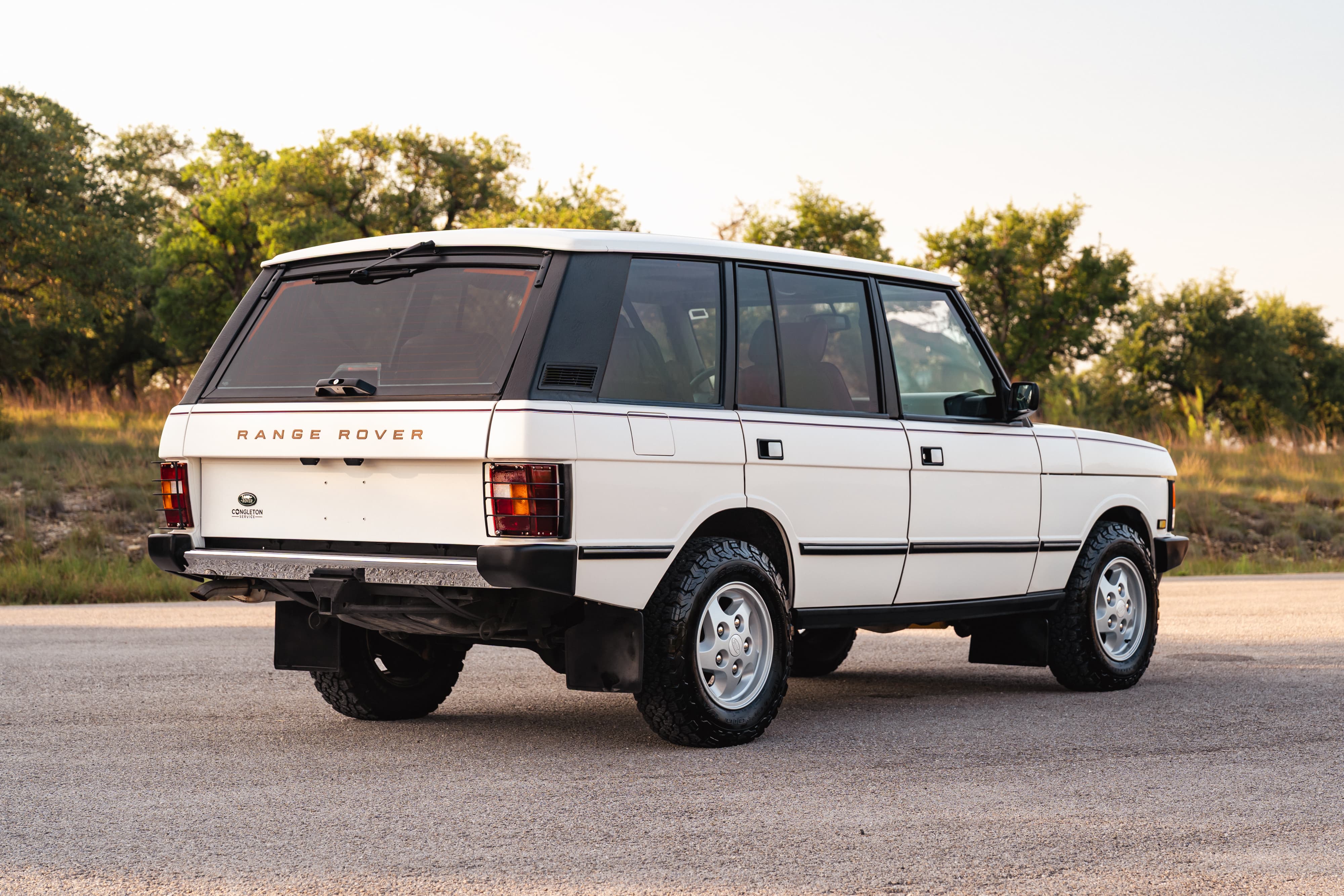 White 1995 Range Rover County LWB with chrome rims, black trim, and copper &quot;Range Rover&quot; badging.