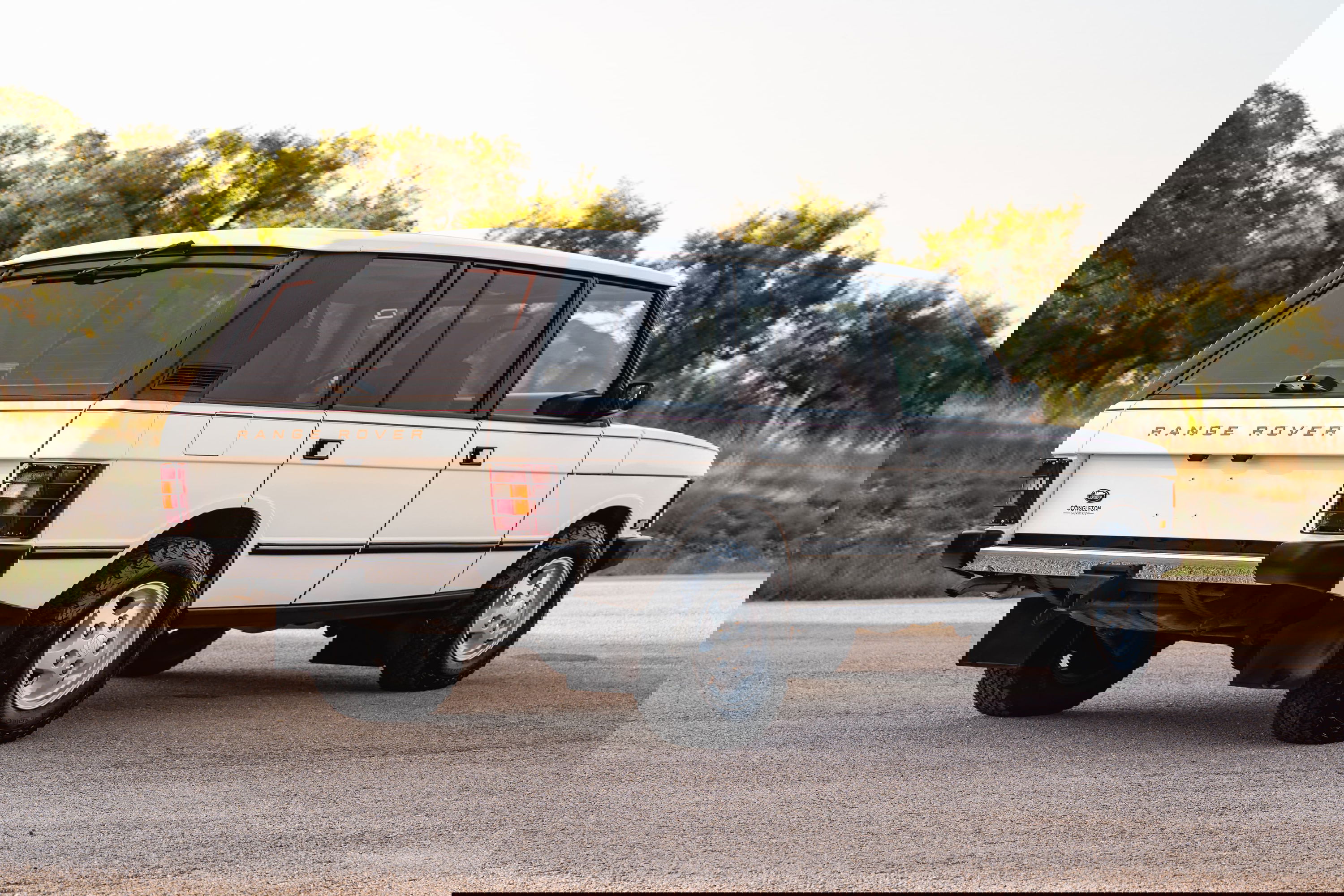 White 1995 Range Rover County LWB with chrome rims, black trim, and copper &quot;Range Rover&quot; badging.