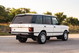 White 1995 Range Rover County LWB with chrome rims, black trim, and copper "Range Rover" badging.