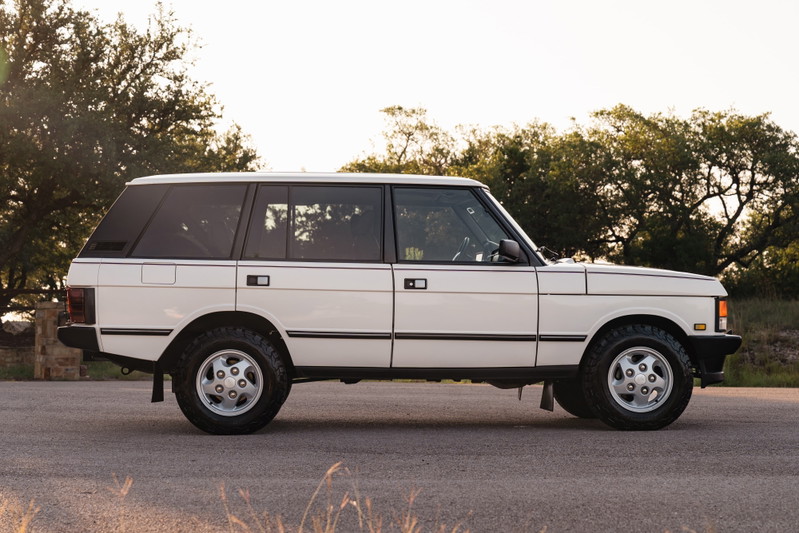 Side profile of a white 1995 Land Rover Range Rover County with silver five-spoke rims.