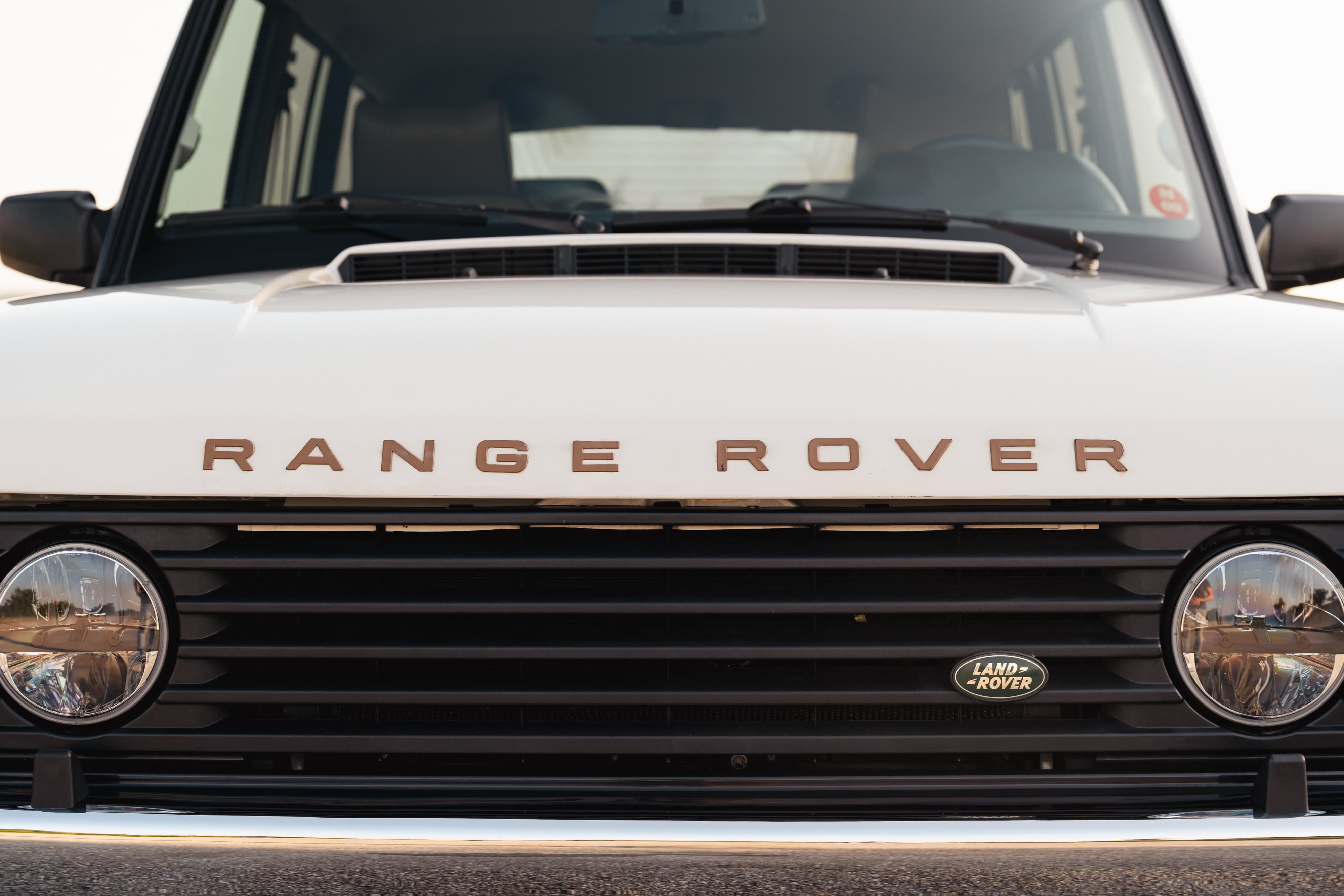 Close-up of the front grille and hood of a white 1995 Land Rover Range Rover County.