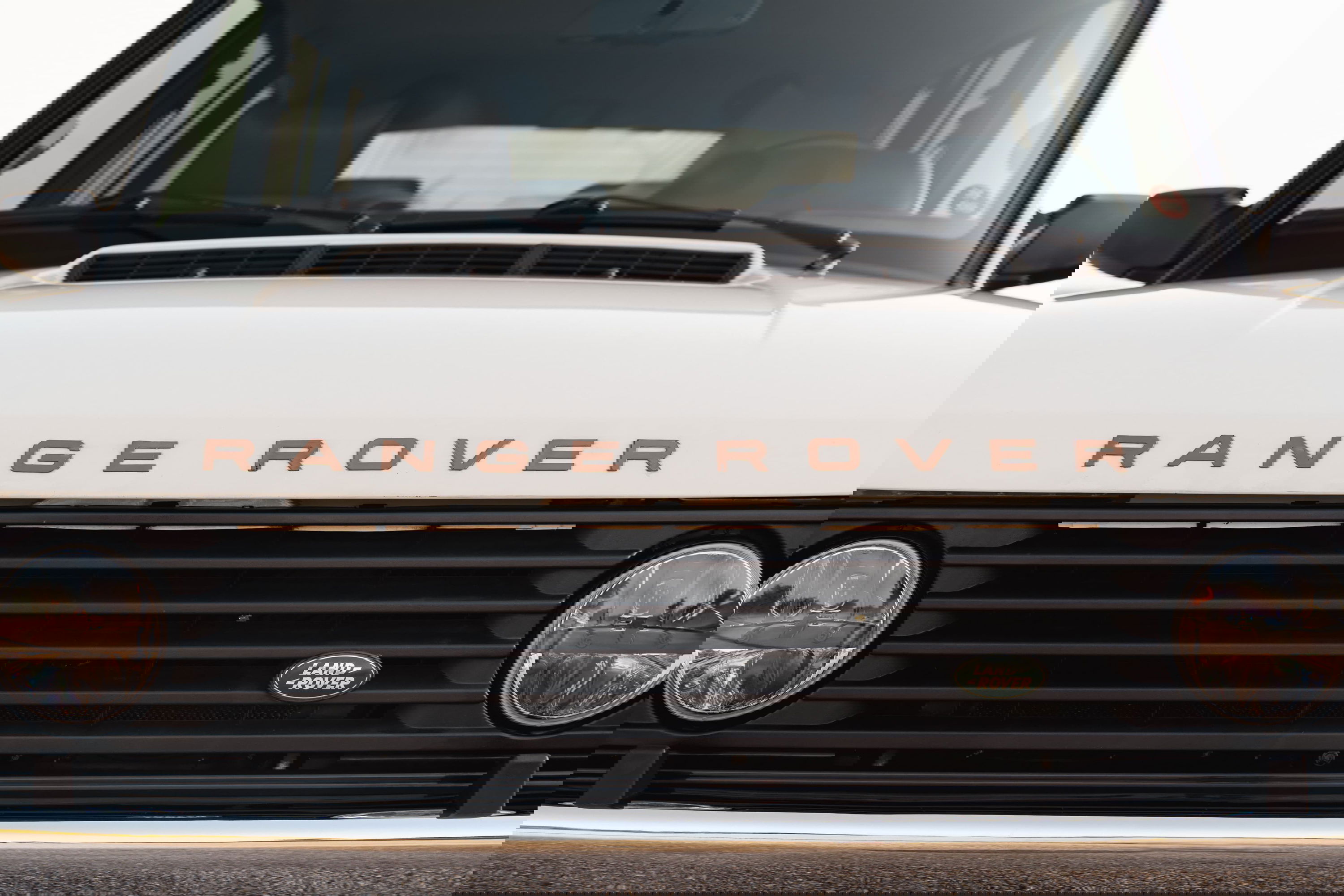 Close-up of the front grille and hood of a white 1995 Land Rover Range Rover County.