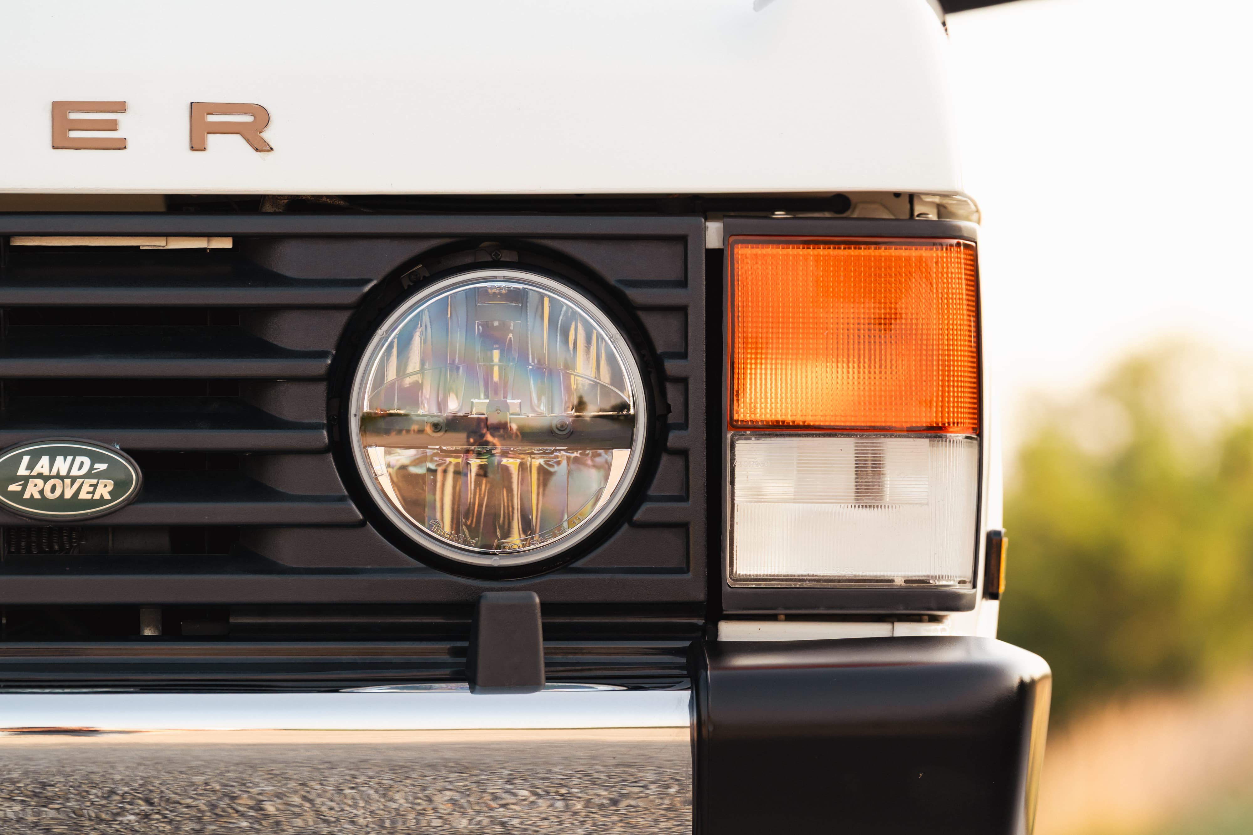 Front view of a white 1995 Land Rover Range Rover County with round LED headlight and amber turn signal.