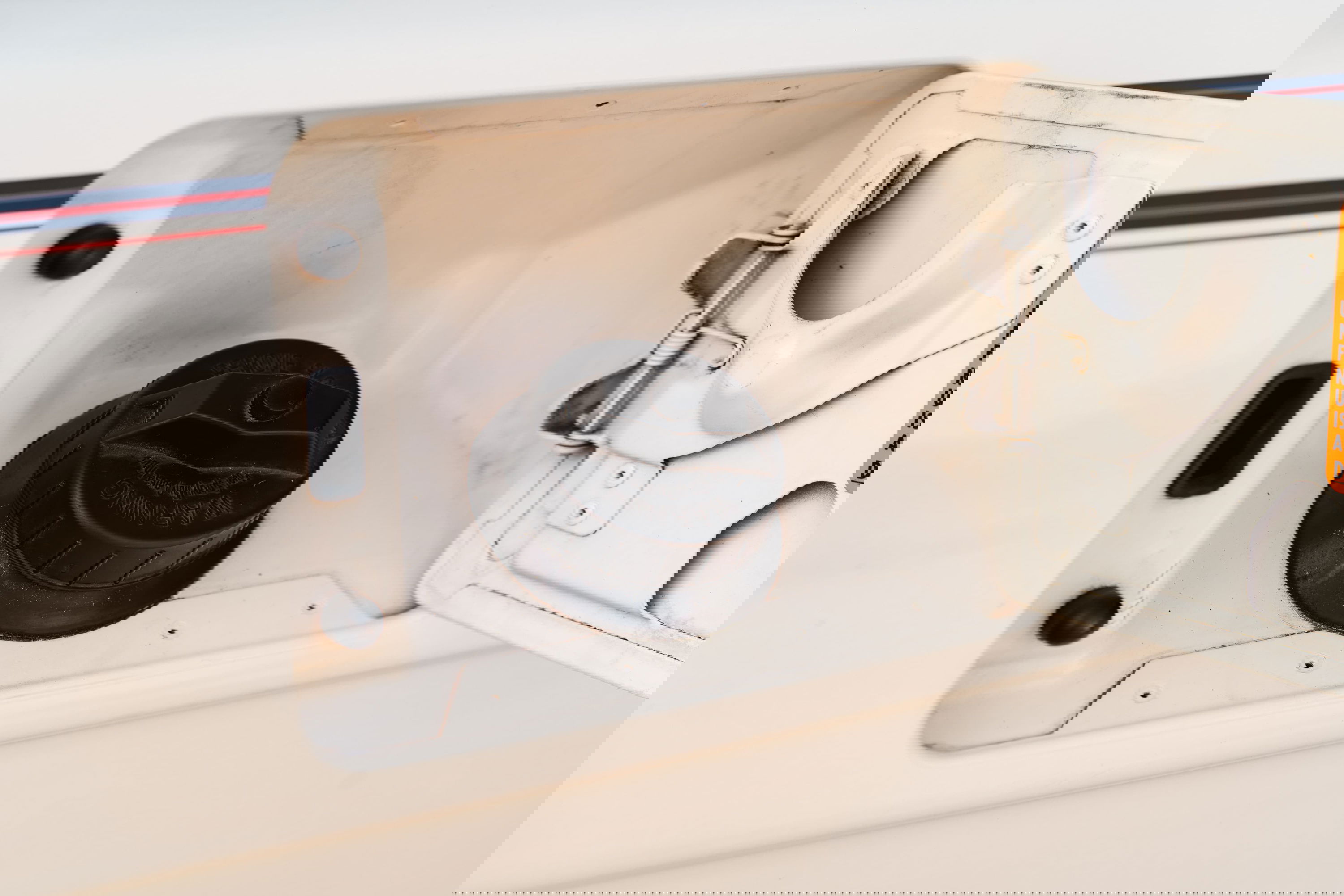 1995 Land Rover Range Rover County white fuel filler door with black cap and red/blue trim.