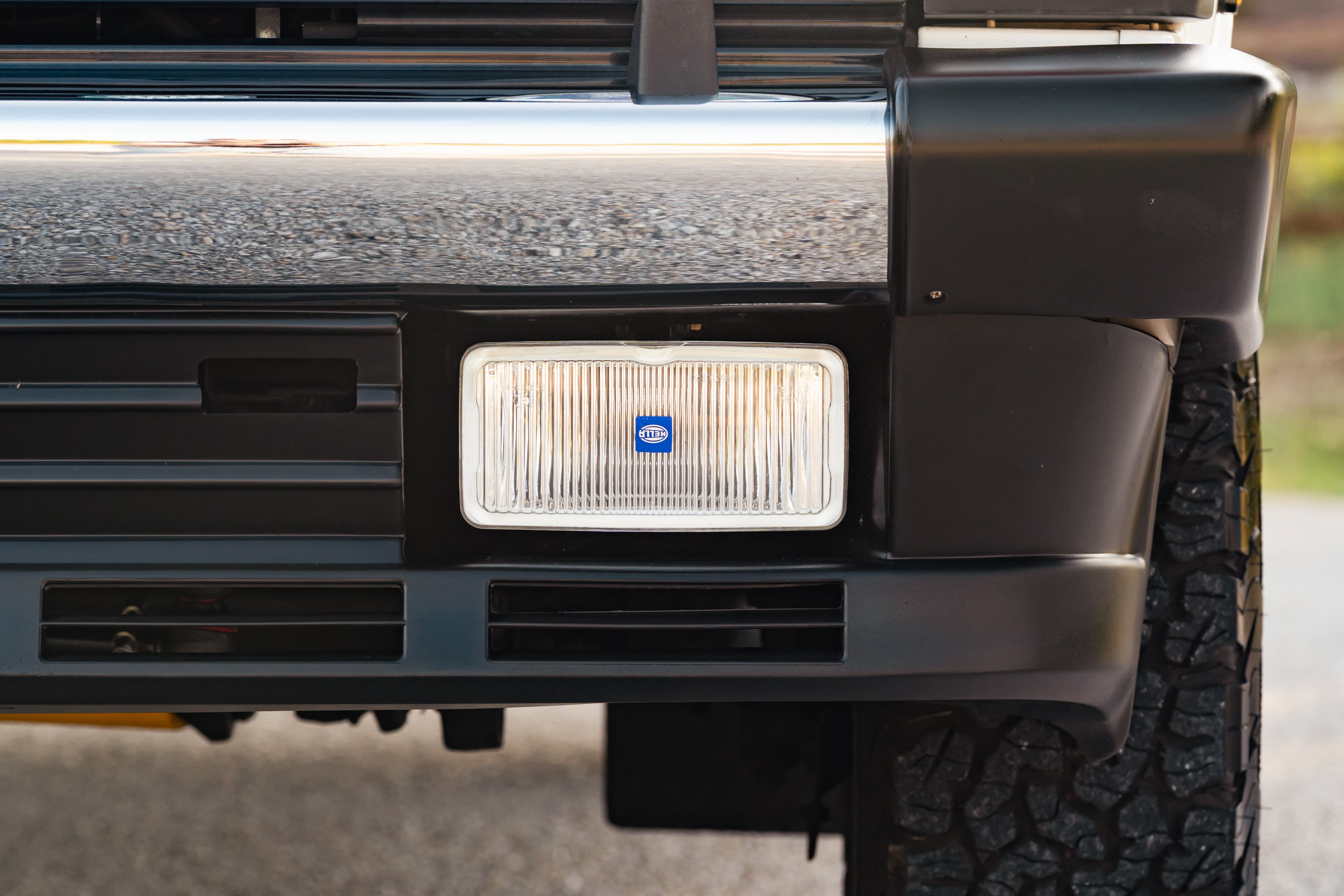 Front view of a white 1995 Land Rover Range Rover County, showing its black bumper and Hella fog light.