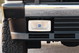 Close-up of a white 1995 Land Rover Range Rover County front bumper with HELLA fog light.