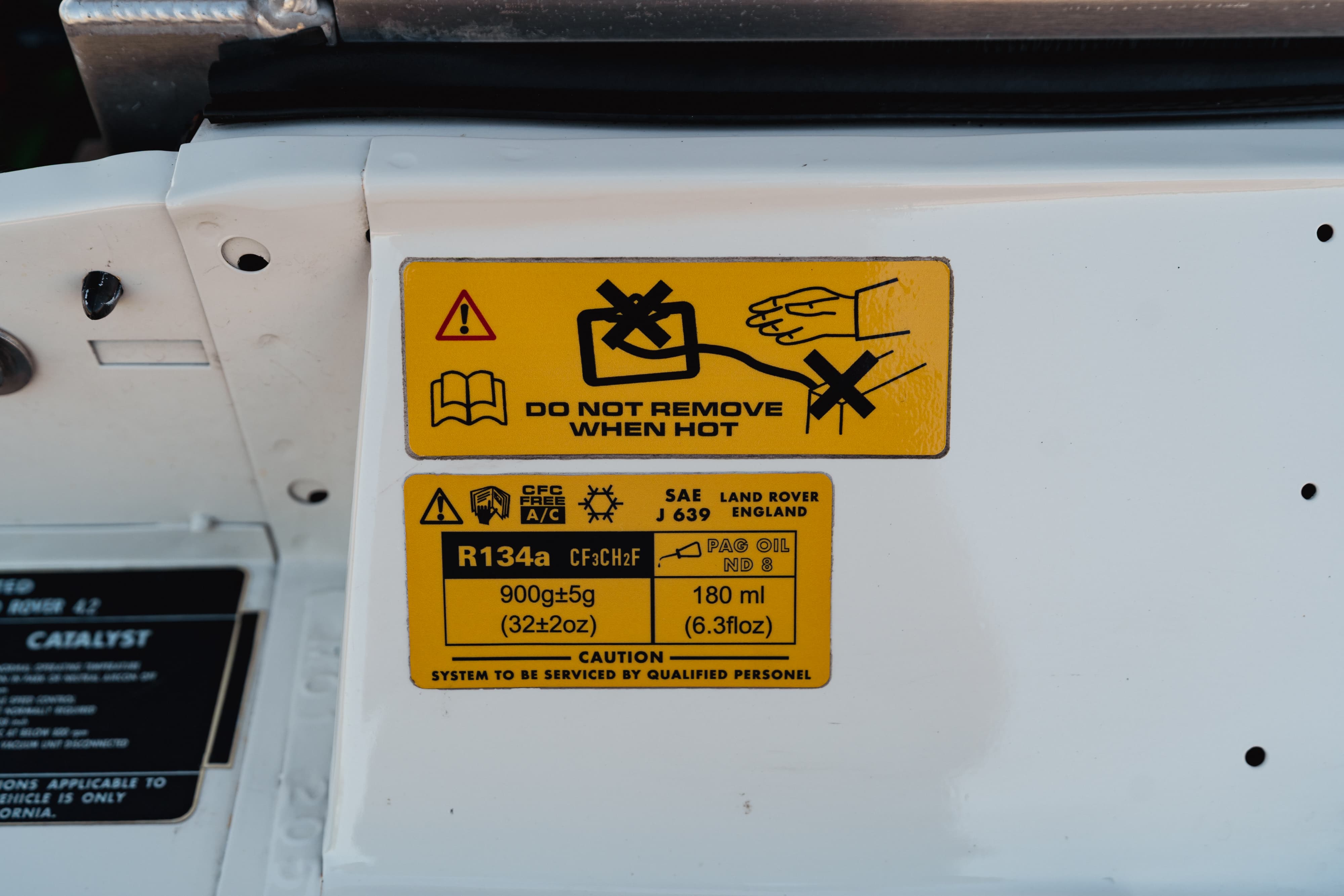 1995 white Land Rover Range Rover County underhood labels, R134a refrigerant charge, PAG oil spec.