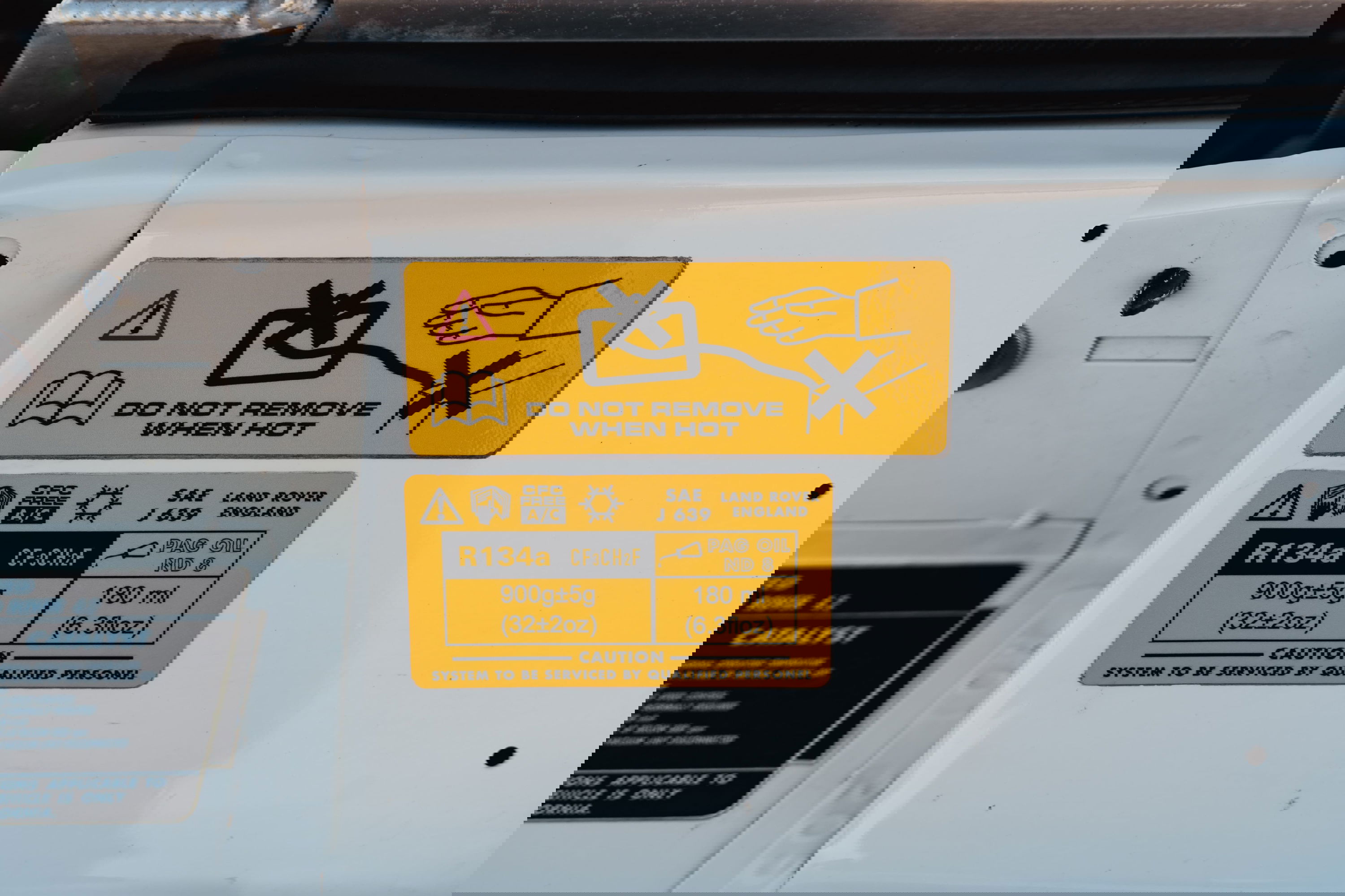 1995 white Land Rover Range Rover County underhood labels, R134a refrigerant charge, PAG oil spec.