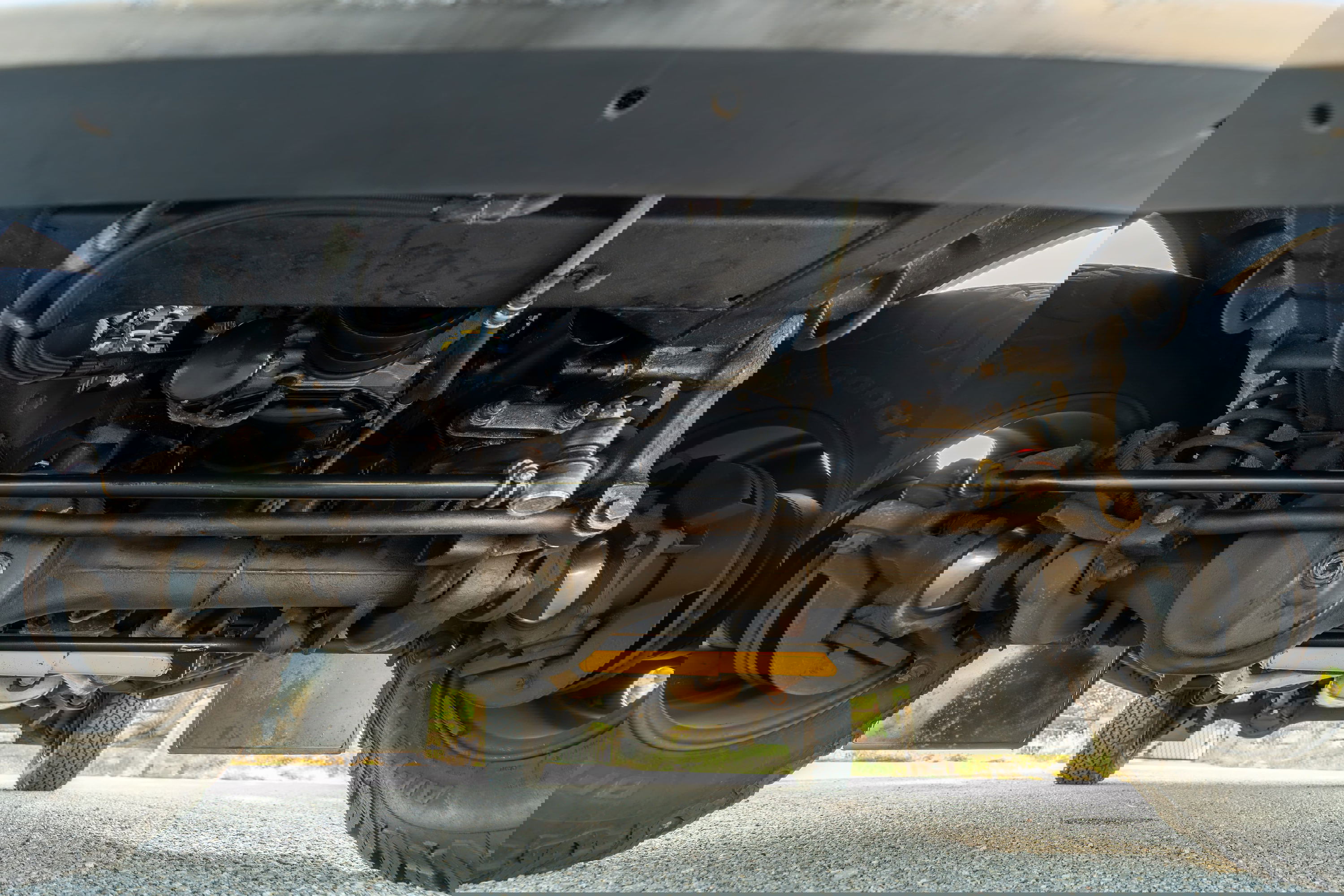 Underside of a white 1995 Land Rover Range Rover County showing suspension and drivetrain.