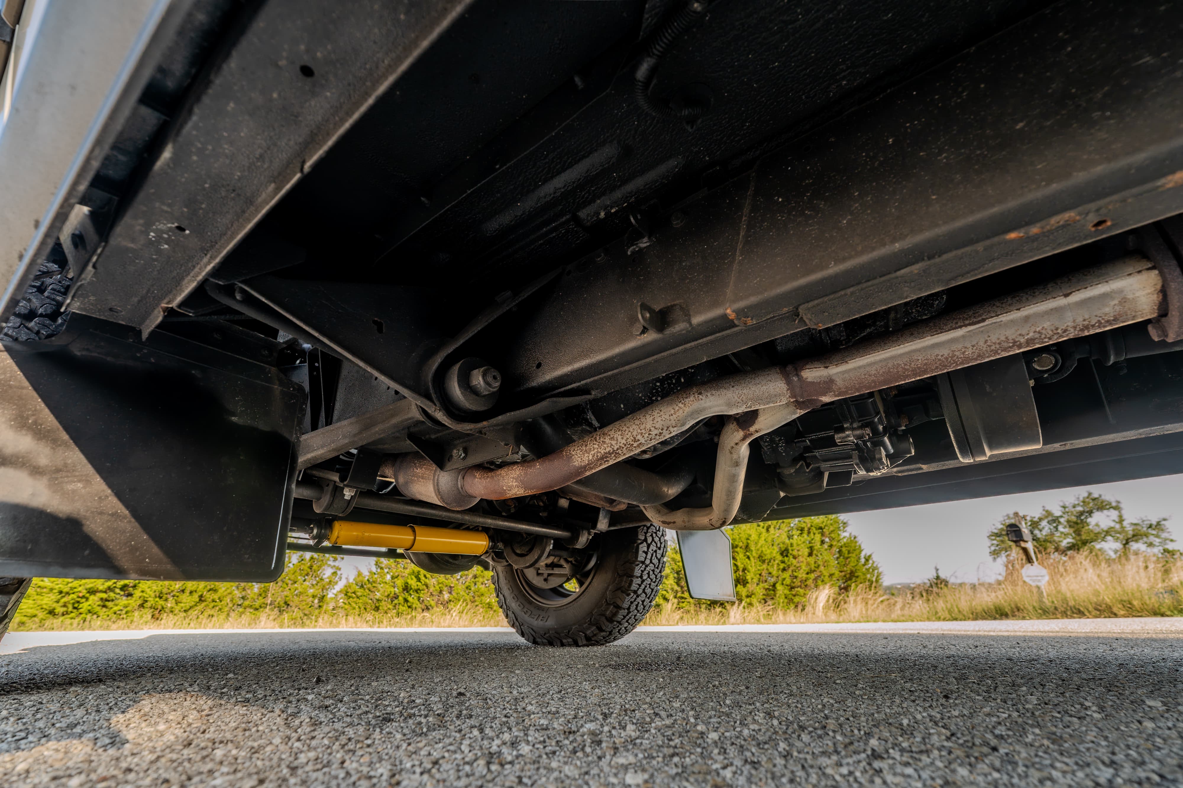 Underside view of a white 1995 Land Rover Range Rover County showing the exhaust system and suspension.