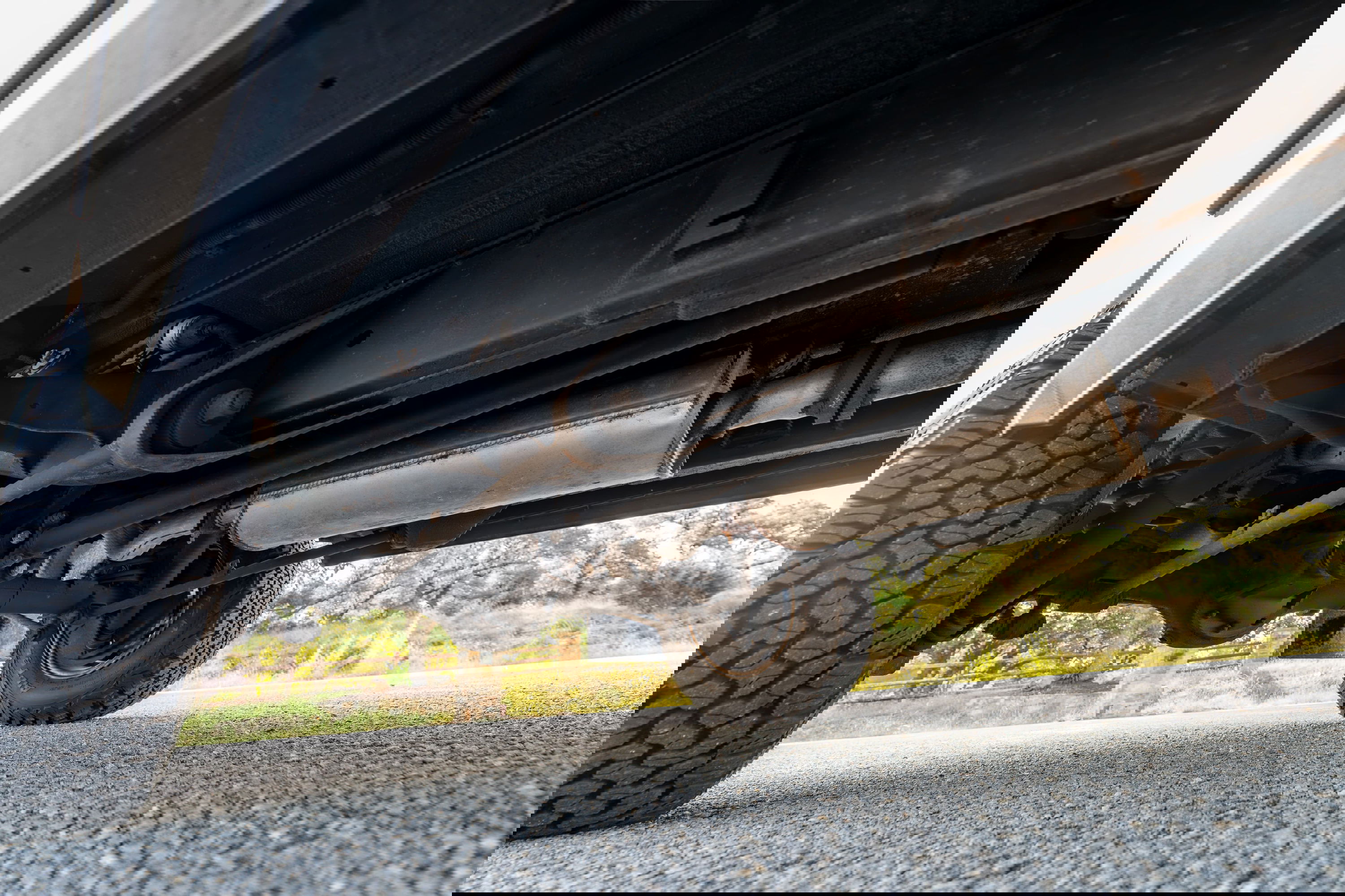 White 1995 Land Rover Range Rover County undercarriage with off-road tires and exhaust.