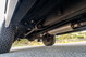 White 1995 Land Rover Range Rover County undercarriage with off-road tires and exhaust.