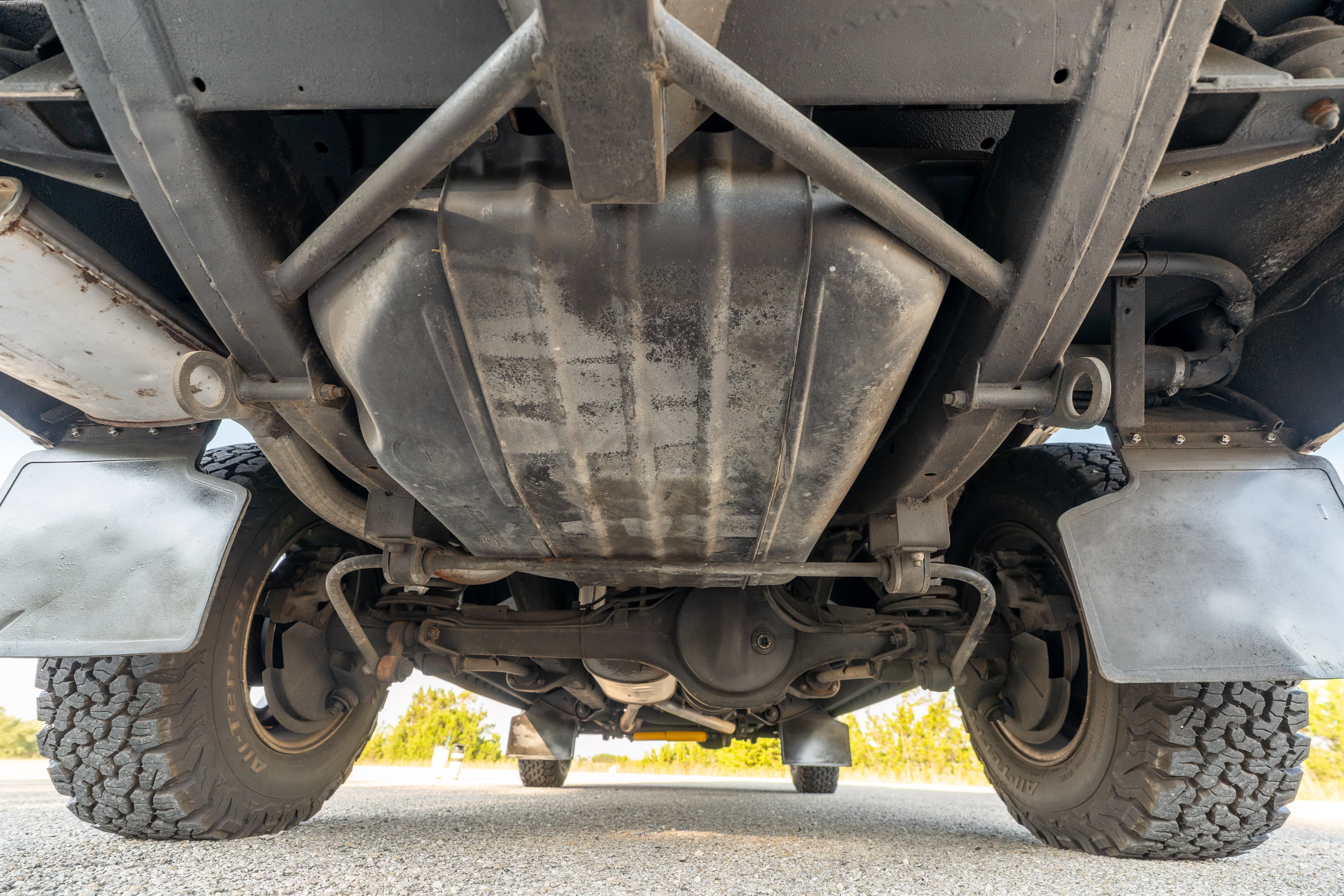 Underside view of a white 1995 Land Rover Range Rover County, showing chassis, fuel tank, and tires.