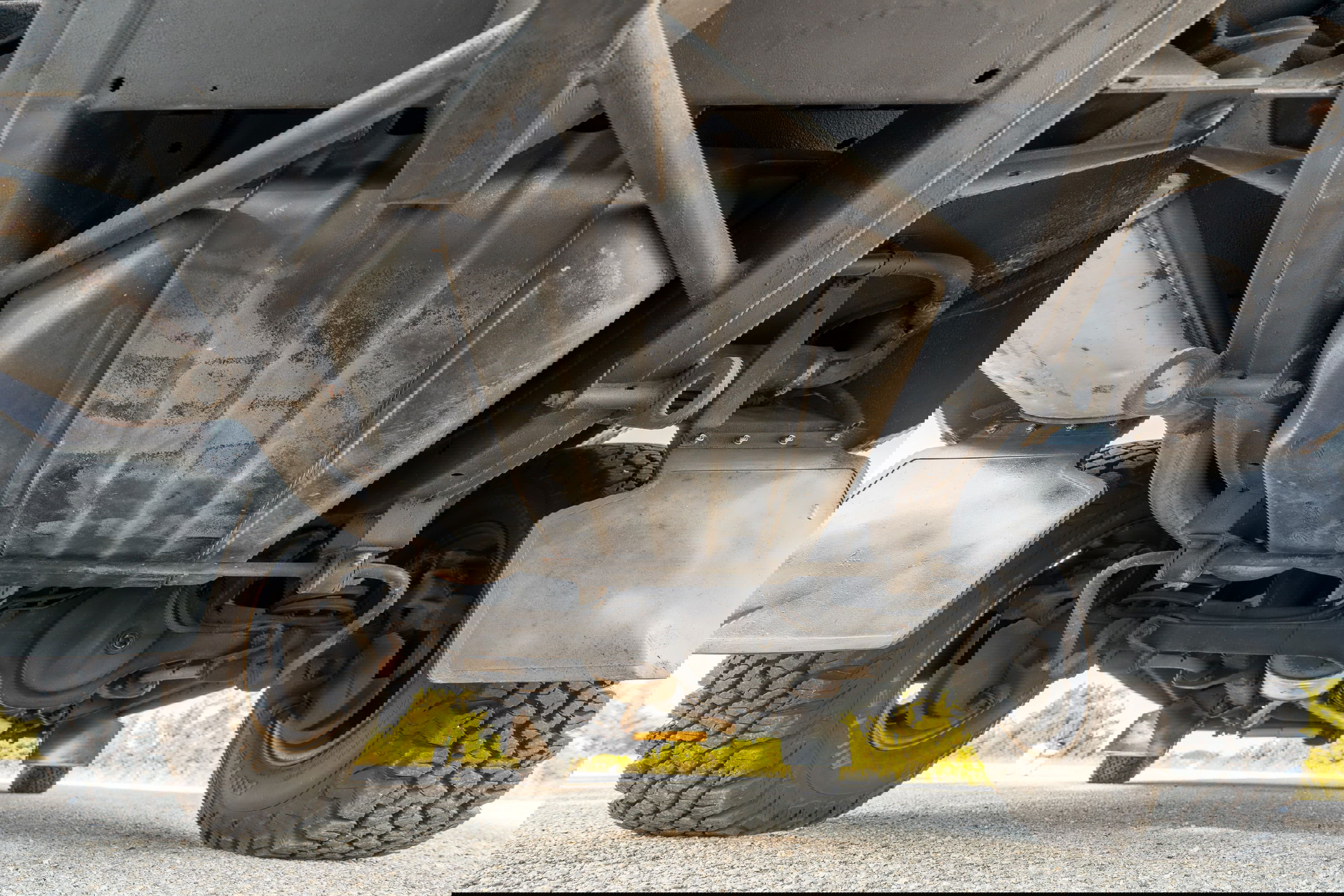 Underside view of a white 1995 Land Rover Range Rover County, showing chassis, fuel tank, and tires.