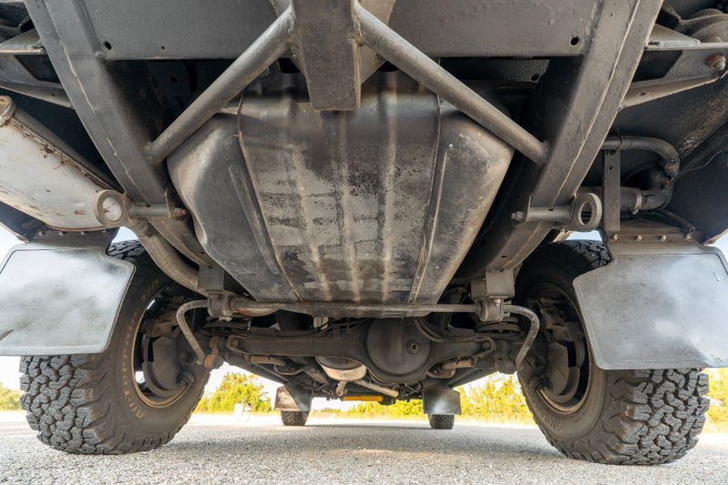 Underside view of a white 1995 Land Rover Range Rover County, showing chassis, fuel tank, and tires.