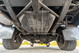 Underside view of a white 1995 Land Rover Range Rover County, showing chassis, fuel tank, and tires.
